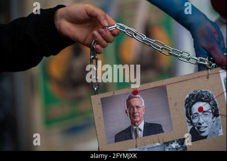 Bogota, Cundinamarca, Colombia. 28 maggio 2021. Un dimostratore porta un banner con una foto dell'ex presidente Alvaro Uribe, E una foto del fumetto ucciso a Bogotà negli anni '90 Jaime Garzon, mentre migliaia si riunivano per protestare contro il presidente della Colombia Ivan Duque Maraquez e i casi di disordini e brutalità della polizia che avevano lasciato almeno 45 morti durante il primo mese di manifestazioni, a Bogotà, Colombia il 28 maggio 2021. Credit: Maria Jose Gonzalez Beltran/LongVisual/ZUMA Wire/Alamy Live News Foto Stock