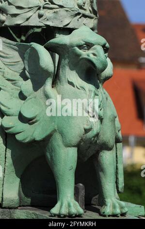 Il corpo di un leone e la testa, le ali e il becco di un'aquila – uno dei griffini verdi o dei granchi che sostengono gli standard delle lampade lungo le balaustre del Ponte del Drago che attraversa il fiume Lubijanica a Lubiana, Slovenia. I grifoni sono compagni di quattro temibili draghi di rame verde molto più grandi che proteggono i quattro angoli della struttura. Il ponte è stato costruito in stile Art Nouveau / Vienna Secession su disegno dell'architetto e ingegnere dalmata Jurij Zaninović (1876-1946) e aperto al traffico nel 1901, quando Lubiana era una città dell'Impero austro-ungarico. Foto Stock