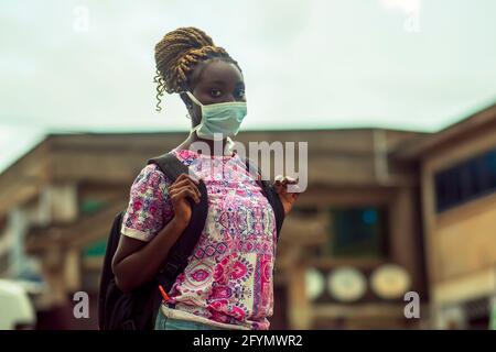 Giovane donna che indossa la maschera per il viso Foto Stock