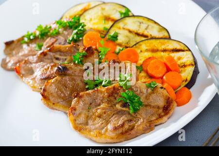 Grigliata di costolette di agnello serviti con melanzane grigliate e carota Foto Stock