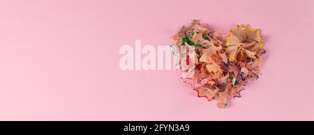 striscione con trucioli colorati a forma di cuore su sfondo rosa. Decorazione per San Valentino. Vista dall'alto Foto Stock