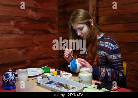 Fare decorazioni di Natale. Immagine di pittura di decoratore femminile su un ornamento di Natale. 10 dicembre 2018. Kiev, Ucraina Foto Stock