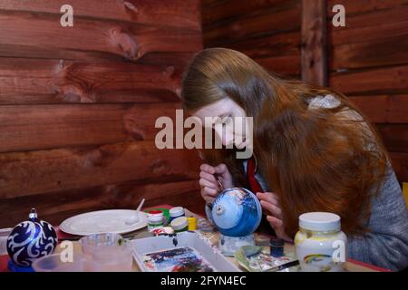 Fare decorazioni di Natale. Immagine di pittura di decoratore femminile su un ornamento di Natale. 10 dicembre 2018. Kiev, Ucraina Foto Stock