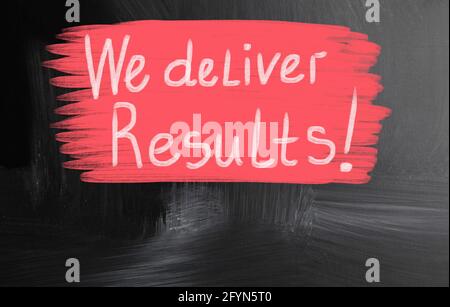 Primo piano di un testo "We deliver results" su sfondo rosso su una superficie nera Foto Stock