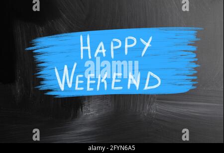 Primo piano di un testo "Happy Weekend" su sfondo blu su una superficie nera Foto Stock