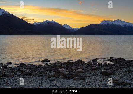 Tramonto sul lago Wakatipu e sulle montagne circostanti nell'Isola del Sud della Nuova Zelanda Foto Stock