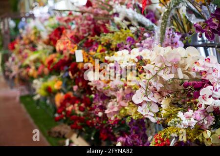 Vetrina colorata di fioreria con ampio assortimento di fiori artificiali Foto Stock