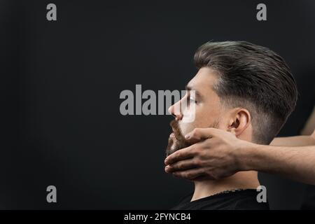 Fissaggio della forma della barba con cera. Il risultato di un taglio di capelli in un barbiere Foto Stock