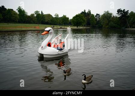 Una famiglia usa un pedalo al Cannon Hill Park a Birmingham, con il fine settimana delle vacanze bancarie previsto per portare i cieli azzurri e sole diffuso. Data immagine: Sabato 29 maggio 2021. Foto Stock