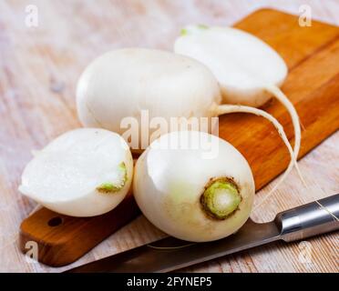 Intero e tagliato in semi mature rape radici raccolti su sfondo di legno. Concetto di nutrizione sana Foto Stock