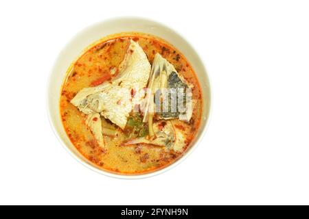 pesce basso bollito speziato con erbe in zuppa di tom yum sul recipiente Foto Stock