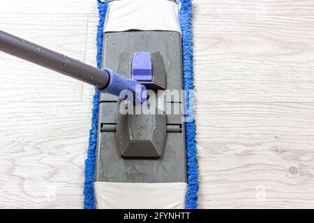 Spazzolatura in plastica blu e grigio che strofina il pavimento leggero nel piatto. Foto Stock