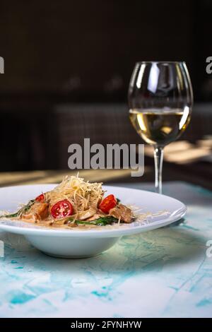 Pasta con formaggi stagionati e carne con vino nel sfondo Foto Stock