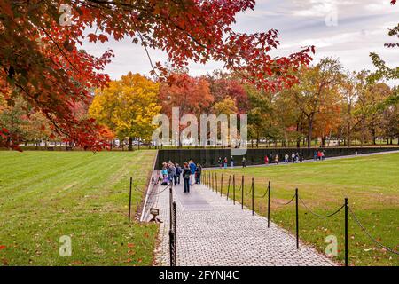 I visitatori del Vietnam Veterans Memorial, dove i nomi dei morti della guerra del Vietnam sono incisi sul muro di granito nero, Washington DC Foto Stock