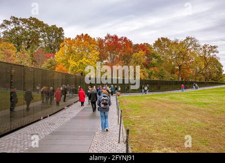 Persone che guardano i nomi incisi sul Vietnam Memorial Wall che onora i membri delle forze armate statunitensi che hanno combattuto nella guerra del Vietnam, Washington Foto Stock