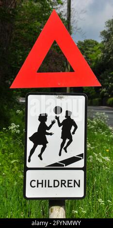 Vecchio stile strada segno 'bambini che giocano' con tradizionale triangolo di avvertimento Foto Stock