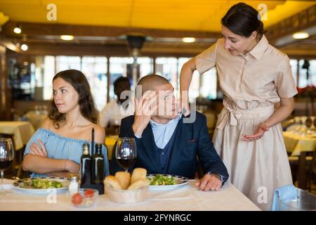 Triangolo d'amore - moglie ha preso il marito con la padrona in un ristorante Foto Stock