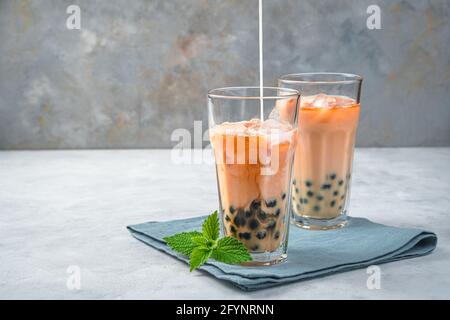 Preparare il tè con tapioca, il tè a bolle su sfondo grigio. Vista laterale, spazio di copia. Foto Stock