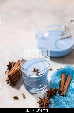 Matta blu in vetro su fondo di cemento chiaro. Tè blu masala tè. Primo piano, spazio di copia. Foto Stock
