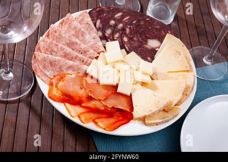 Delizioso piatto di affettati e formaggi, servito come antipasto Foto Stock