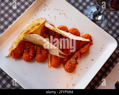 Tradizionale muhammara di acuka piccante turca - salsa di peperoni e noci cosparsa di sesamo e servita con fette di pita Foto Stock