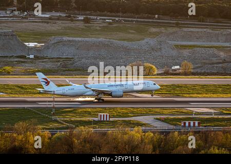 AEROPORTO ADOLFO SUAREZ, MADRID BARAJAS, SPAGNA - Mar 16, 2021: Aeroporto Madrid Barajas, Spagna. 16 marzo 2021. White China Eastern Aircraft atterrando sul Th Foto Stock