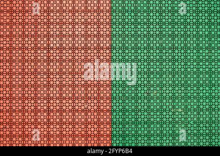 Rivestimenti in gomma mista arancione e verde realizzati in quadratini antiscivolo. È stato realizzato per esercizi all'aperto in stadi, parchi giochi, luoghi sportivi Foto Stock