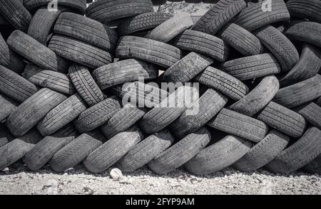 Gli pneumatici per auto sono impilati in pile di grandi dimensioni durante la riparazione dell'auto negozio Foto Stock