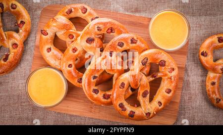 Colpo di pretzel con pancetta e salsa cheesy su un legno Foto Stock