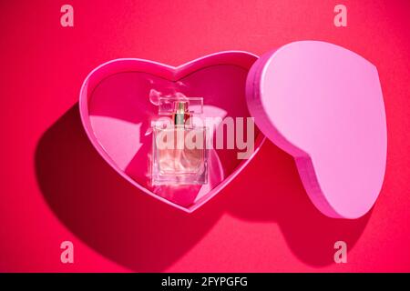 Profumo all'interno di una scatola regalo a forma di cuore isolata su  sfondo rosso con spazio libero per il testo Foto stock - Alamy