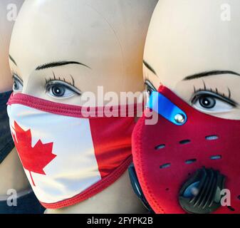 Teste manichine che mostrano maschere facciali Covis-19 personalizzate e creative con un Progettazione di bandiere canadesi Foto Stock