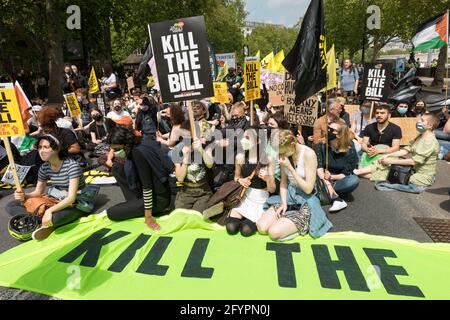 I manifestanti che detengono cartelli si siedono in solidarietà contro il disegno di legge del governo per l'aumento del budget di polizia durante la protesta di Kill Bill.nel marzo 2021, il governo britannico ha proposto il Police and Crime Bill 2021, con l'intento di espandere i diritti della polizia. Dalla sua pubblicazione, ha incontrato un diffuso scetticismo da parte del pubblico e successivamente è diventato oggetto di proteste. Questa protesta, il 29 maggio 2021, è stata guidata dal ramo britannico della Black Lives Matter, combattendo specificamente contro l'uso del potere della polizia come mezzo per tacere le voci nere, in risposta ai recenti assassinii di neri da parte della polizia. T Foto Stock