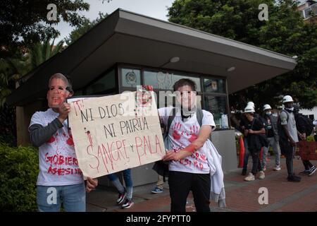 Bogota, Cundinamarca, Colombia. 28 maggio 2021. I manifestanti indossano maschere del presidente IvÃ¡n Duque e del ministro della Difesa Diego Molano mentre tengono un segno che recita: ''né dio né paese, sangue e pallottola.'' in una nuova giornata di proteste a BogotÃ¡ nel quadro della commemorazione di un mese dell'inizio dello sciopero nazionale in Colombia contro il governo di IvÃ¡n Duque, il 28 marzo 2021. Credit: Daniel Romero/LongVisual/ZUMA Wire/Alamy Live News Foto Stock