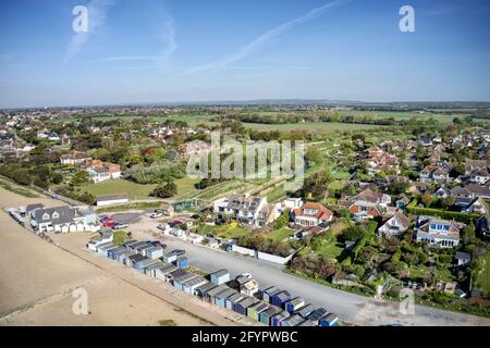 Ferring lungomare sulla Manica con il fucile di Ferring che corre vicino al villaggio di Ferring nel Sussex occidentale e verso le capanne di spiaggia. Foto Stock