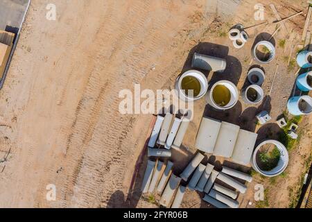 Materiale di costruzione su pila di nuovi tubi di calcestruzzo fognature di tombino fognature in costruzione Foto Stock