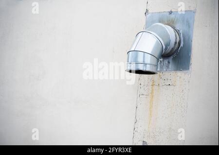 Camino fumi fissata alla costruzione di parete esterna in acciaio inox da scarico impianto caldaia a camera Foto Stock