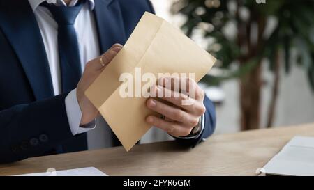 Mani di uomo d'affari apertura busta di carta, prendendo fuori lettera Foto Stock