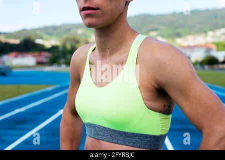 Crop donna sudata in una pista atletica Foto Stock