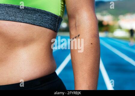 Crop donna sudata in uno stadio di atletica Foto Stock