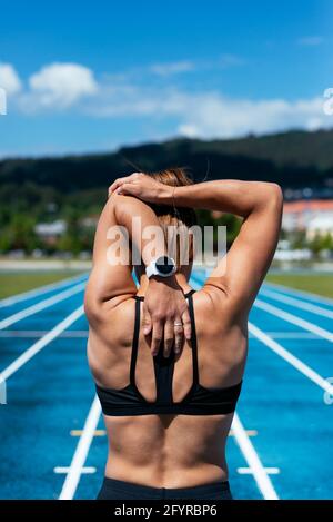 Giovane atleta sulla schiena si riscalda prima di allenarsi Foto Stock