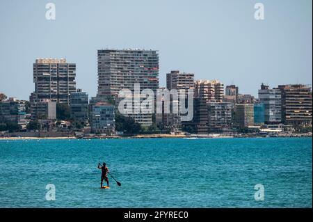 Alicante, Spagna. 29 maggio 2021. Un uomo che paddling godendo le alte temperature nella spiaggia di El Postiguet di Alicante. La Comunità valenciana ha rilasciato questo lunedì nuove misure di restrizione contro il coronavirus (covid-19), tra le altre, sulle spiagge non sarà più necessario indossare una maschera nei periodi di riposo prima o dopo il bagno e rispettando la distanza minima di 1.5 metri con altre persone che non vivono insieme, con un massimo di 10 persone. Credit: Marcos del Mazo/Alamy Live News Foto Stock