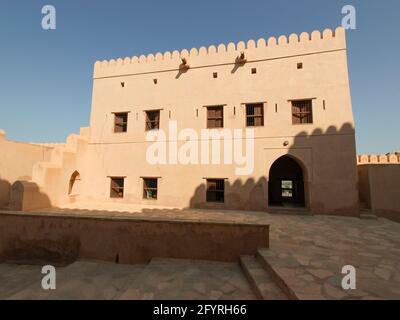 Uno degli edifici in stucco beige. All'antico, antico, restaurato Forte Nakhal lungo la strada di Rustaq. In Oman. Foto Stock