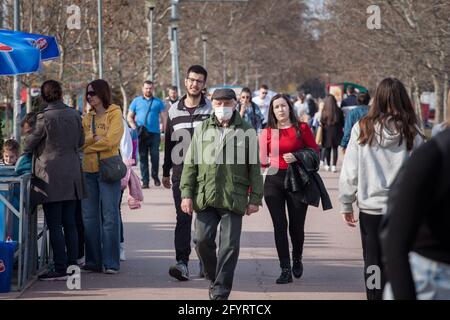 BELGRADO, SERBIA - 27 MARZO 2021: Anziano che indossa una maschera respiratoria accanto a una gente più giovane in folla che non ne indossa una durante il coronav Foto Stock