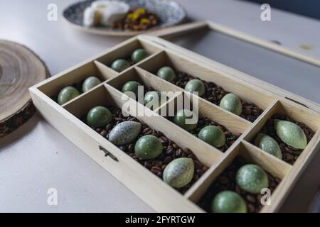 Un primo piano di piccoli biscotti in una scatola di legno sopra la tavola con diversi dessert su di essa Foto Stock