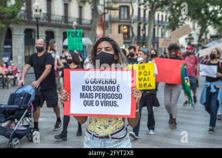 Barcellona, Spagna. 29 maggio 2021. Un manifestante che tiene un cartello che dice, il governo Bolsonaro è più pericoloso del virus, durante la manifestazione.il giorno segnato da manifestazioni nelle principali città del Brasile contro il presidente brasiliano, Jair Bolsonaro. I brasiliani di Barcellona hanno protestato sulle Ramblas di Barcellona per unirsi alle proteste del loro paese natale. (Foto di Thiago Prudencio/SOPA Images/Sipa USA) Credit: Sipa USA/Alamy Live News Foto Stock