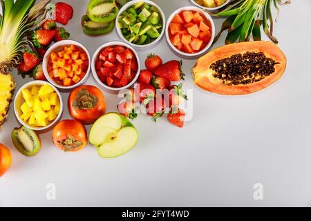 Tropicale colorato frutta intera e tagliata su sfondo bianco. Foto Stock