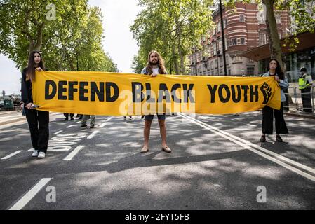 Londra, Regno Unito. 29 maggio 2021. I manifestanti hanno un banner che dice difendere i giovani neri durante la manifestazione.nel marzo 2021, il governo britannico ha proposto la legge sulla polizia e sul crimine 2021, con l'intento di estendere i diritti della polizia. Dalla sua pubblicazione, ha incontrato un diffuso scetticismo da parte del pubblico e successivamente è diventato oggetto di proteste. Sasha Johnson, l'attivista Black Lives Matter ha sostenuto una ferita alla testa a Peckham domenica 23 maggio (Foto di May James/SOPA Images/Sipa USA) Credit: Sipa USA/Alamy Live News Foto Stock