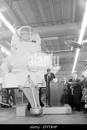 12 settembre 1962 il presidente John F. Kennedy (al leggio) fa commenti, dopo un tour delle mostre di veicoli spaziali all'interno di un hangar presso il Rich Building del presidiato Spacecraft Center, Houston, Texas. Il presidente Kennedy possiede un modello in scala del modulo di comando Apollo, presentato a lui dal direttore del presidiato Spacecraft Center, il dottor Robert Gilruth; un mock-up del lander lunare (noto anche come 'il Bug') si trova a sinistra in background. In piedi: Direttore delle operazioni per il progetto Mercury, Dr. Walter C. Williams; amministratore associato della National Aeronautics and Space Administration Foto Stock