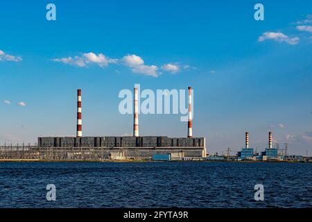 La centrale idroelettrica opera e produce energia e elettricità sulla riva di un bacino idrico in città Foto Stock