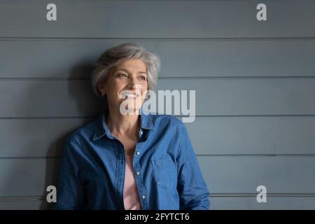 Donna attraente più anziana con capelli corti grigi in posa in studio Foto Stock